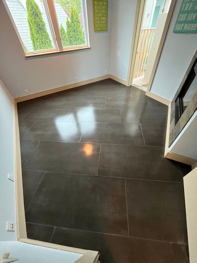 Charcoal large-format floor at an entry with a door and sidelights