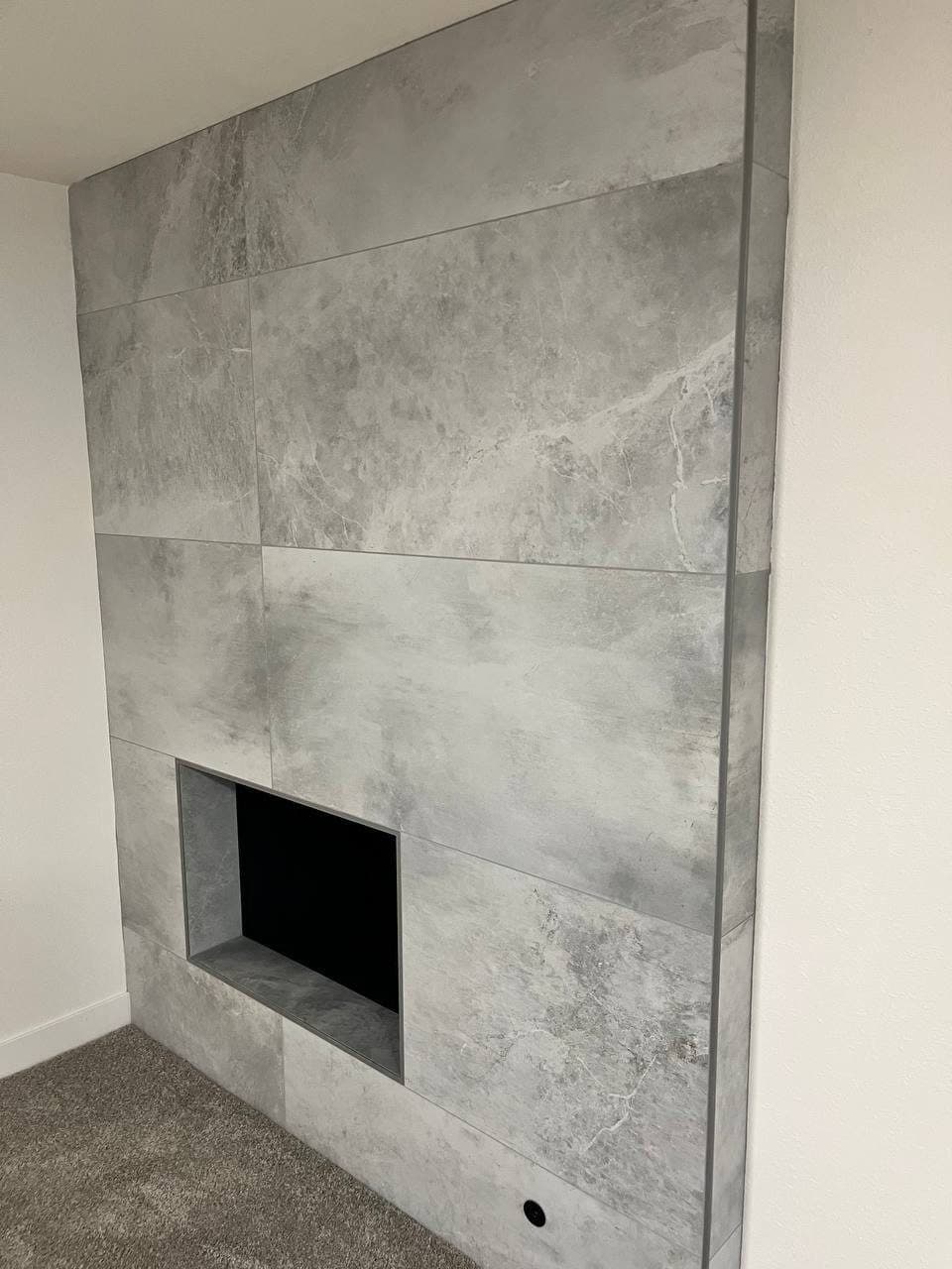 Floor-to-ceiling fireplace wall in gray large-format porcelain