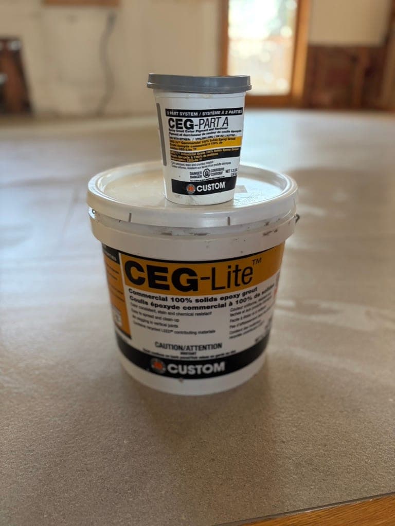 Bucket of two-part epoxy grout on a freshly set floor
