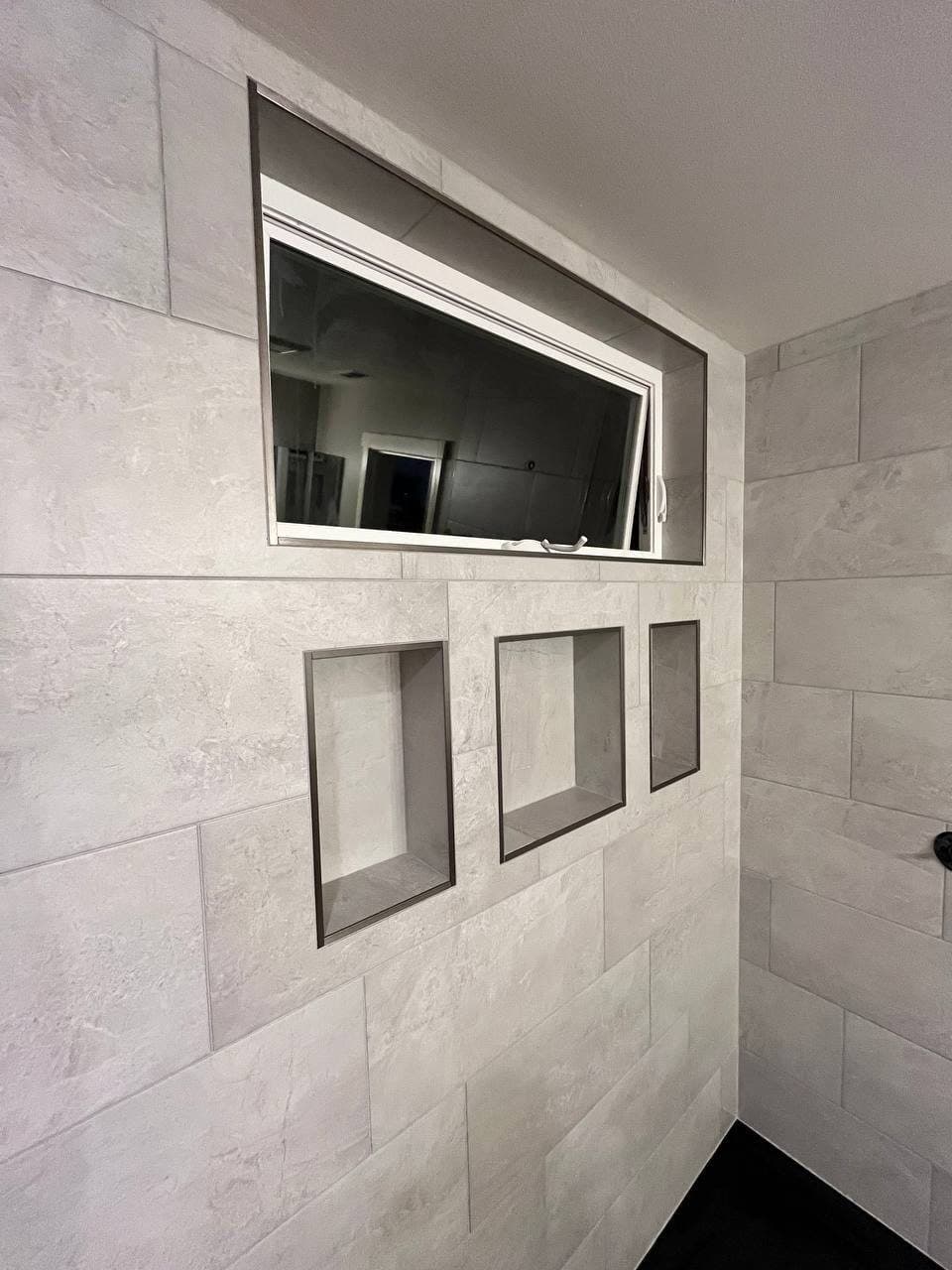 Shower wall in stone-look porcelain with three recessed niches