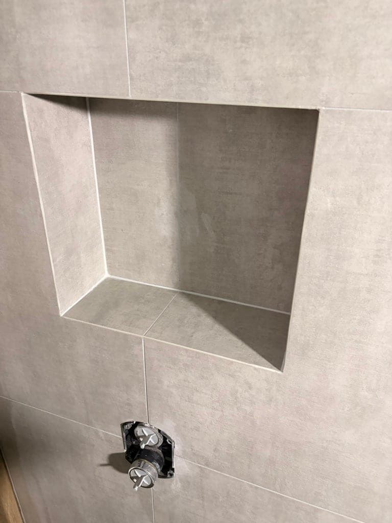 Recessed niche in concrete-look porcelain with mitered inside edges