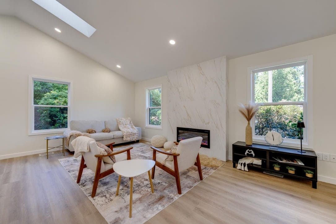 Floor-to-ceiling marble-look porcelain fireplace wall with a linear fireplace and skylight above